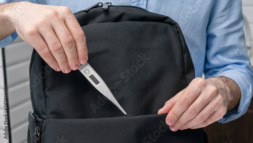 Wallpaper Mural Man takes an electronic thermometer with him on the road, puts the thermometer in a backpack, male hands, cropped image, close-up, 16:9 Torontodigital.ca