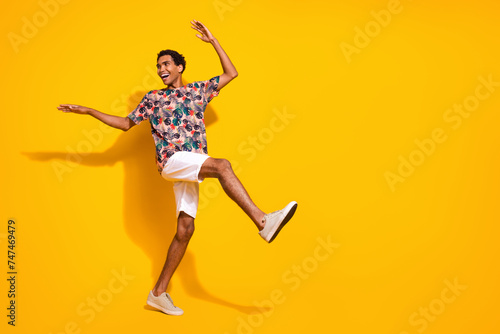 Full body length size photo of young funky positive man steps wearing casual summer clothing dance isolated on yellow color background