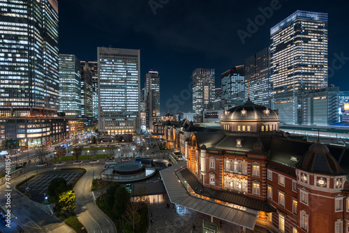 Night view of modern office buildings and historic landmark Tokyo Station in the Marunouchi district of Tokyo, Japan.