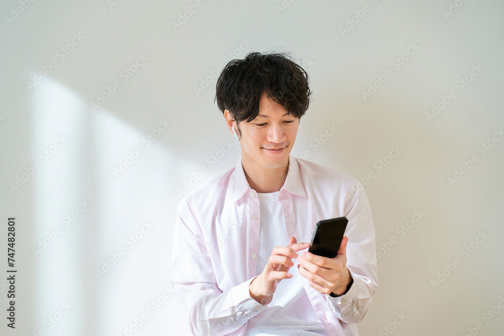 スマートフォンを手にしている若い男性 スマートフォンを手にしている若い男性