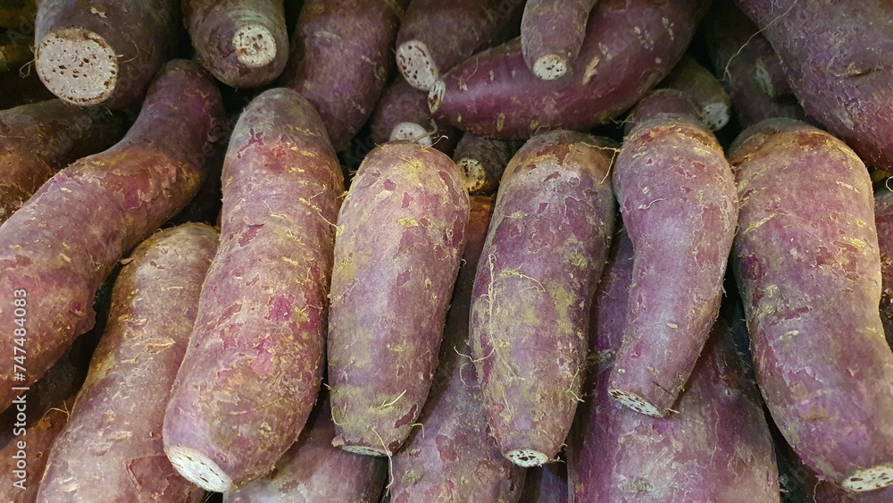 Close up pile of fresh sweet potatoes sold at the market as a background.
Close up pile of fresh sweet potatoes sold at the market as a background.