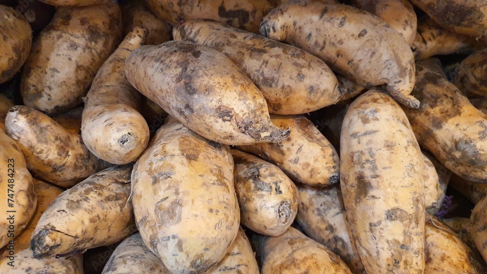 Close up pile of fresh sweet potatoes sold at the market as a background. Close up pile of fresh sweet potatoes sold at the market as a background.