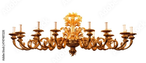 A grand gold chandelier adorned with multiple candles attached to it, illuminated against a plain white background.