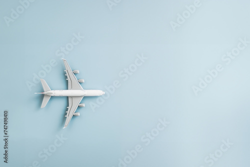 avion de ligne miniature isolé sur un fond bleu très clair avec espace négatif pour texte copyspace. Départ en vacances, long courrier, voyages, exotisme, voyager, agence de voyage, réservation