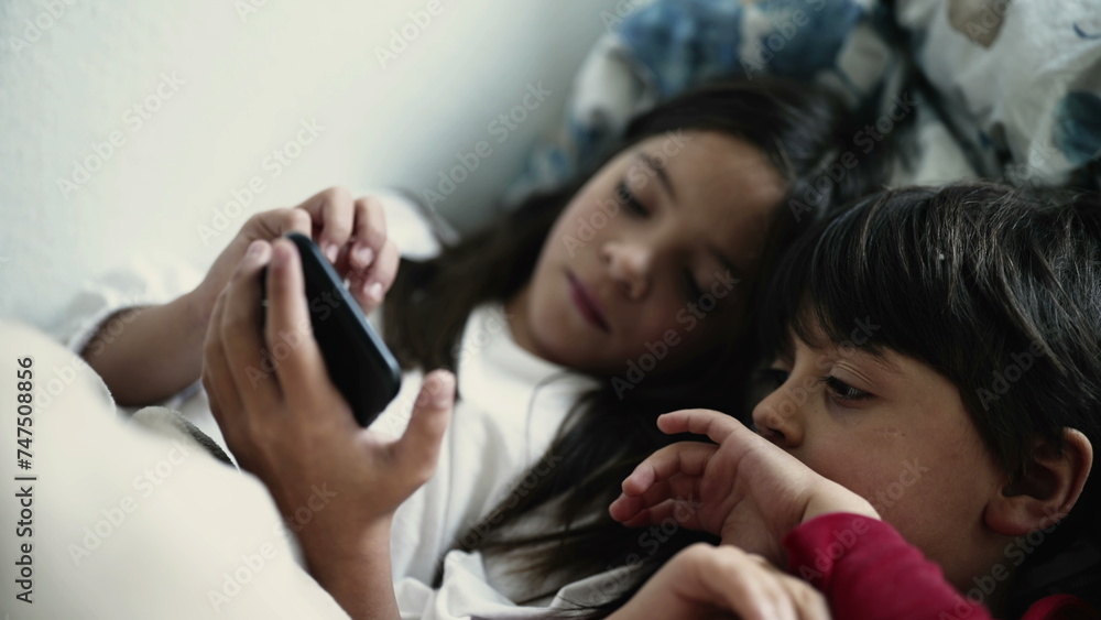 Brother and Sister Engrossed in Smartphone Screen While Lying in Bed, Siblings Bonding Over Digital Device Brother and Sister Engrossed in Smartphone Screen While Lying in Bed, Siblings Bonding Over Digital Device