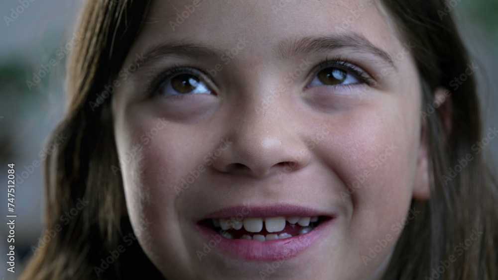 Macro close-up of joyful little girl smiling at camera, tight facial features of 8 year old child feeling happy Macro close-up of joyful little girl smiling at camera, tight facial features of 8 year old child feeling happy