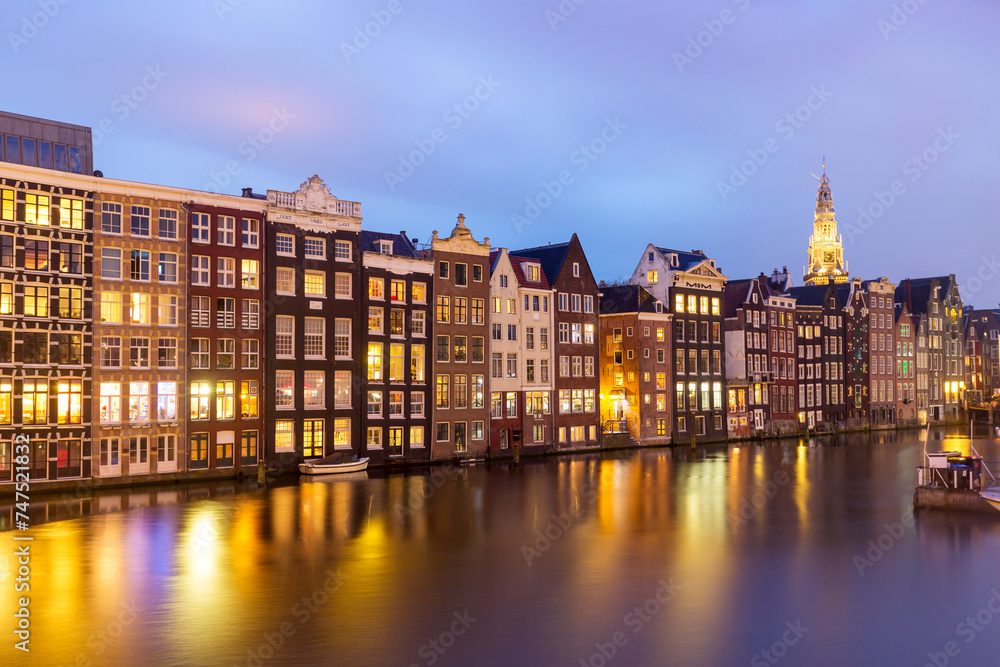 Typical old dutch houses over canal with reflections at twilight in Amsterdam, North Holand, Netherlands. Amsterdam postcard.