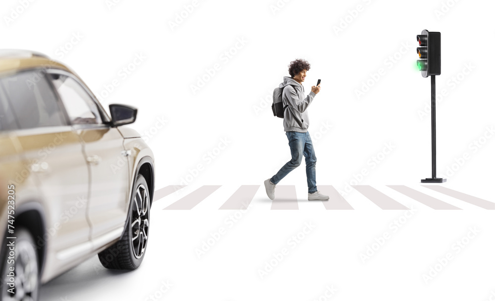 Guy walking at a pedestrian crossing with a smartphone in his hands in front of a vehicle Guy walking at a pedestrian crossing with a smartphone in his hands in front of a vehicle