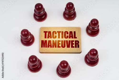 On a white background, pawns stand around a sign with the inscription - Tactical Maneuver