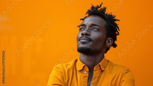Portrait of a confused puzzled minded African American man in orange top isolated on orange background,