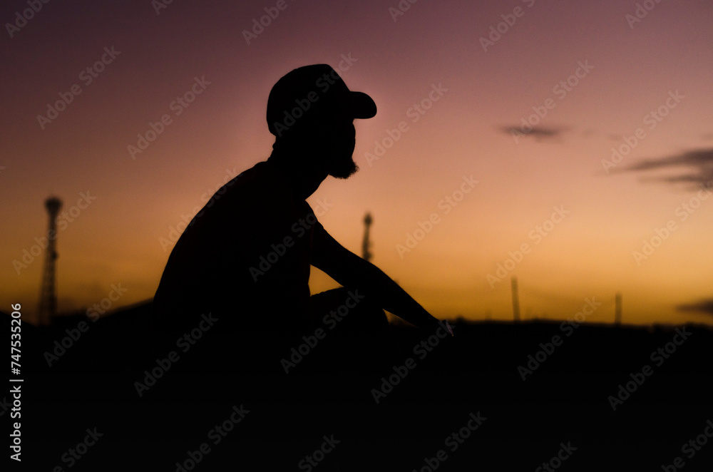 Silhouette of a young man watching the sunset