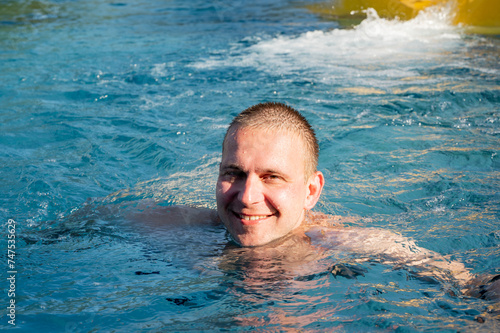 Man relaxing in swimming poll. 