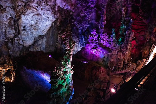 Natural cave with stalactites and stalagmites with lighting.