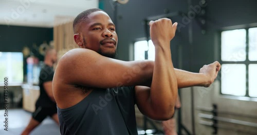 Fitness, gym and black man stretching arms for healthy body, wellness or exercise at club. Warm up, training and serious African person workout for flexibility, sports or physical activity of athlete photo
