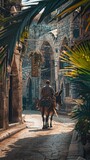 A man rides a donkey along the street of the old city, palm leaves in the right corner of the frame, a card or banner for Palm Sunday