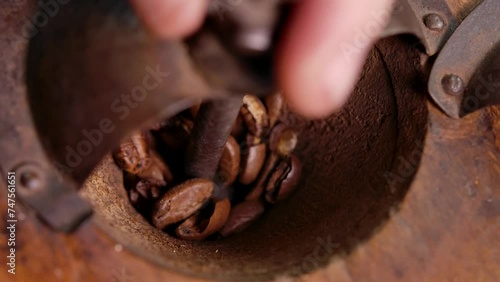 Close up view of the vintage coffee grinder rotating and grinding roasted coffee beans. High quality 4k footage photo