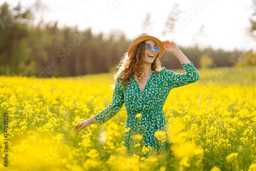 Happy woman enjoying nature on the field. Nature, vacation, relax and lifestyle. Summer landscape. © maxbelchenko