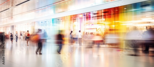 Wallpaper Mural A blurred image capturing a bustling scene in a shopping mall, with numerous individuals walking around. The motion blur conveys a sense of movement and activity within the mall. Torontodigital.ca