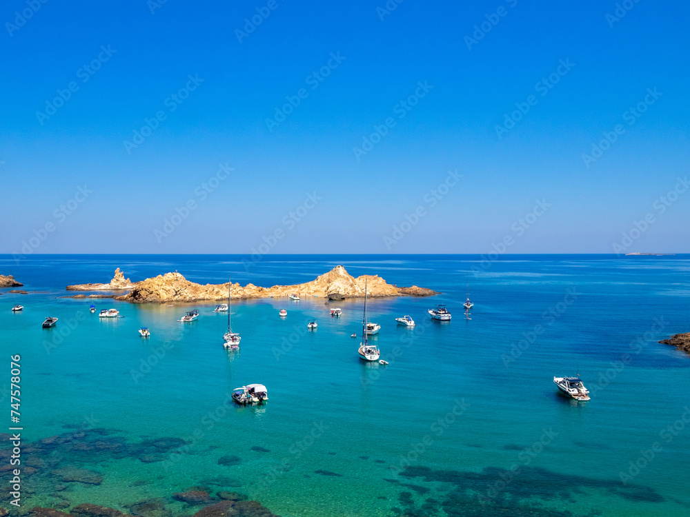 Sailboats in the turquoise sea of Cala Pregonda, Menorca