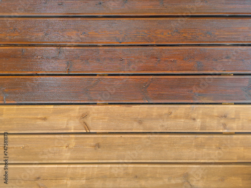 Partially painted and partly cleaned fluted wood terrace impregnated with oil. Top view of decking of wooden planks