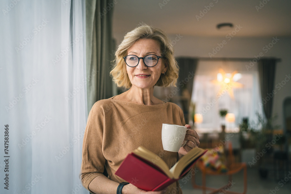 One woman mature caucasian female read book at home wear eyeglasses One woman mature caucasian female read book at home wear eyeglasses
