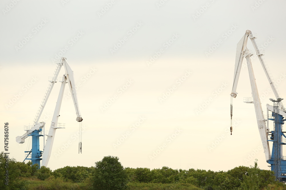 View of cranes in port at evening time View of cranes in port at evening time