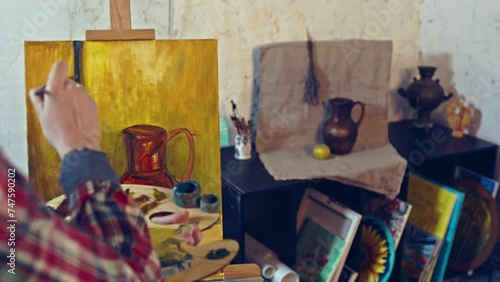 Young girl drawing a picture from nature in her workshop. Art workshop with a big window.  