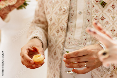 Le marié indien mangeant avec les doigts pendant le cocktail photo