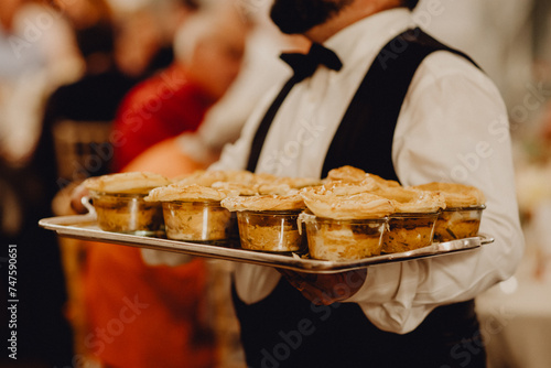 Obraz na plátně Le serveur portant le plateau et les repas des invités