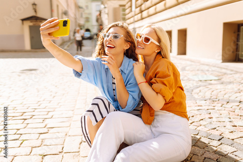 Young friends having fun and take selfie on the phone together. Lifestyle, leisure, entertainment, youth concept.