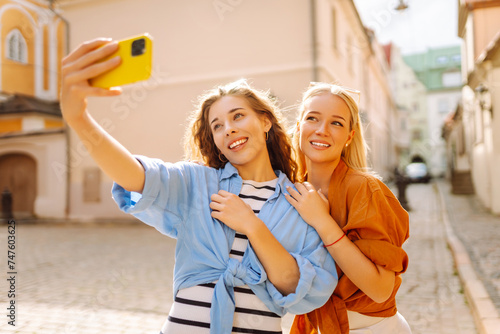 Young friends having fun and take selfie on the phone together. Lifestyle, leisure, entertainment, youth concept.