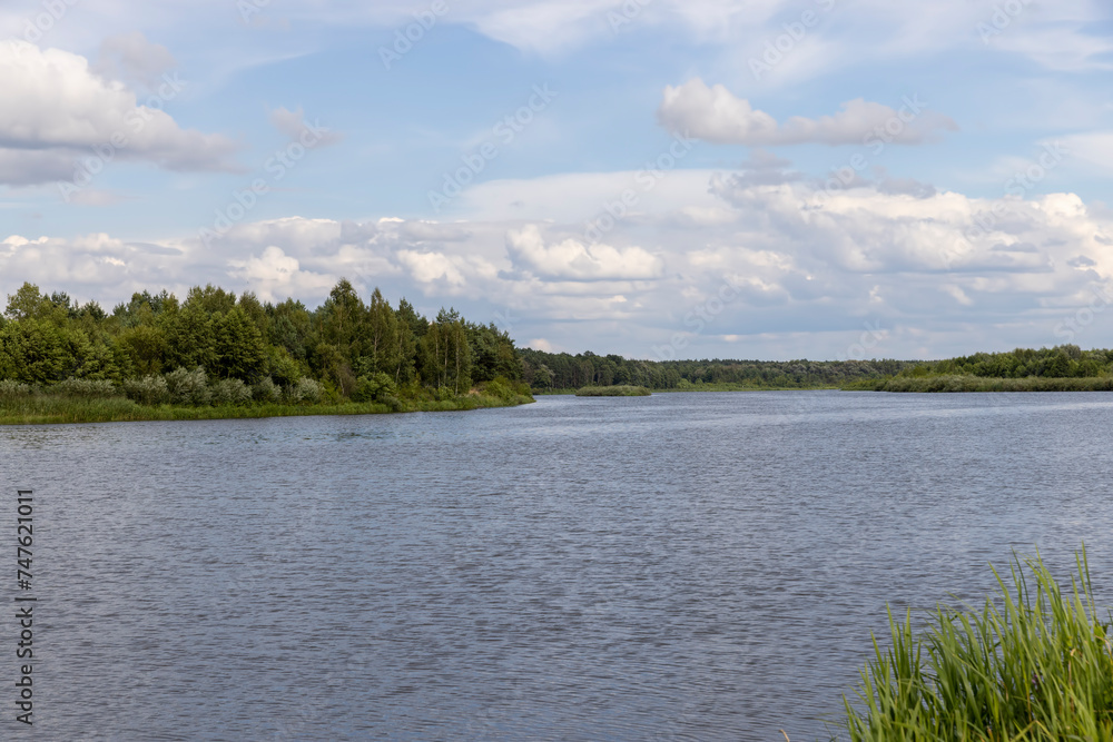 water with waves in the river in summer with green grass