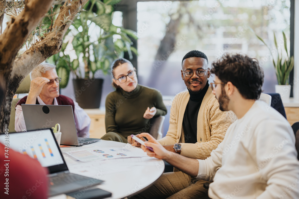 © qunica.com - Team strategizing business growth and profitability. Collaborating on market expansion, sales, and marketing success. Effective multi-generational, multiethnic teamwork in the corporate office.