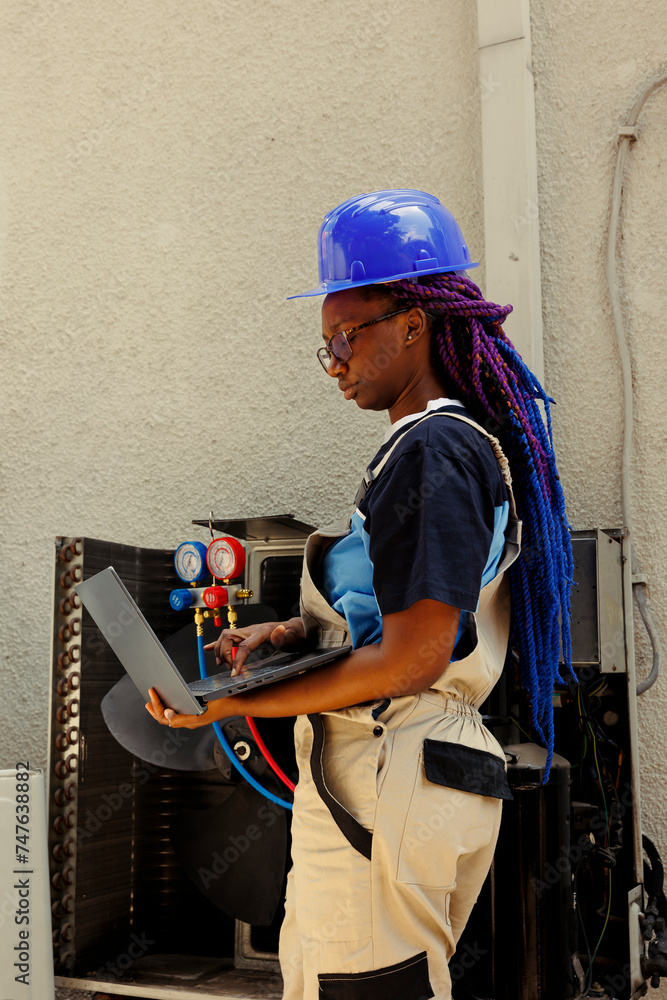 African american meticulous expert looking online for new air filters to replace outdoor air conditioner malfuntioning internal part during customer comissioned maintenance African american meticulous expert looking online for new air filters to replace outdoor air conditioner malfuntioning internal part during customer comissioned maintenance