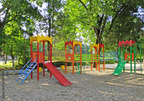 children's playground in the shade of the trees of a city park. small slides and ladders for play and entertainment for the little ones
