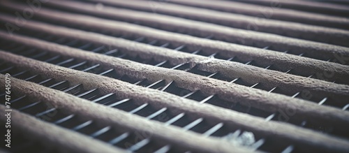 A detailed view of a dirty metal grill on an HVAC system, filled with dust and debris, requiring immediate cleaning and disinfection to prevent allergies and respiratory illnesses. photo