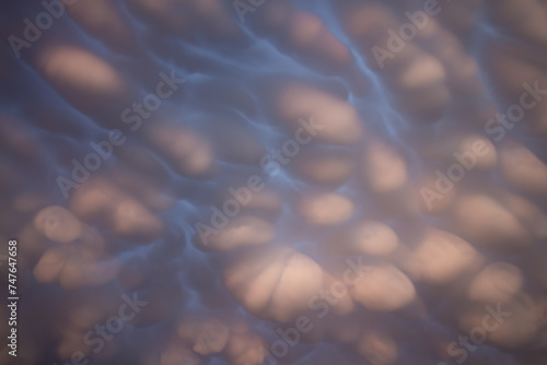 Mammatus clouds in the sky overhead create an other worldly display. Light from the setting sun gives them a pink hue.