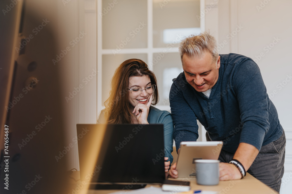 Multi generational teammates collaborating on a successful project in an innovative workplace, analyzing market growth and finding solutions. Multi generational teammates collaborating on a successful project in an innovative workplace, analyzing market growth and finding solutions.