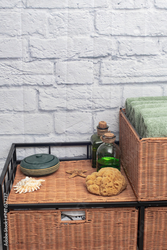 Wicker furniture in bathroom interior design with stacks of bath towels.