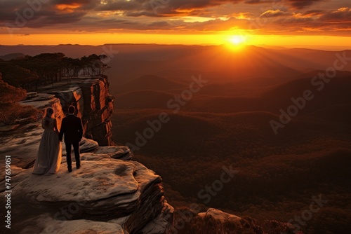 Wedding couple on cliff at sunset overlooking Blue Mountains, Australia. Vibrant sky with fluffy clouds and lush greenery. Romantic moment in natures stunning backdrop