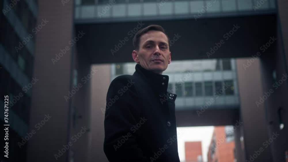 Businessman posing in front of buildings Businessman posing in front of buildings