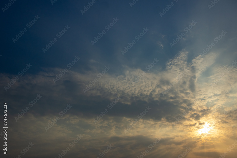 Sunset sky with clouds and rays of light. Nature background.