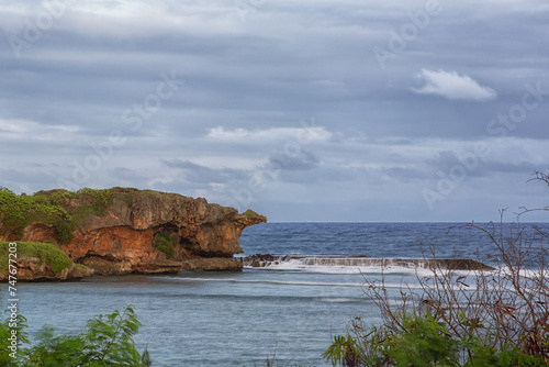 Jagged rocky coastline of Inarajan as a storm rolls in on Guam photo