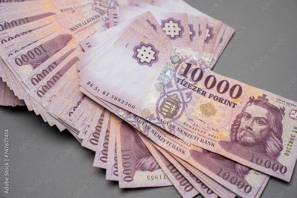 Fototapeta premium Hungarian banknote bundle money (forint) 10,000 HUF banknotes spread out on a table, close-up as background. Europe Hungary.