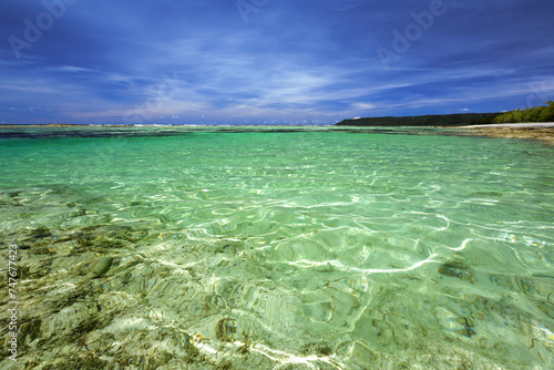 Clear tropical waters at Serena Beach, Guam with a view of Ratidian Point and blue skies in the distance. photo