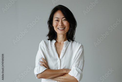 Confident Professional Asian Businesswoman Posing in a Modern Office Setting with a Positive Attitude and Smile