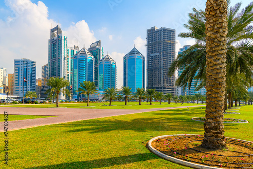 The skyline of downtown Sharjah from the waterfront Corniche Central Souq Park along Khalid Lake at Al Majaz Waterfront, Sharjah, United Arab Emirates. photo