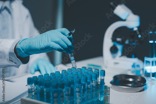 Many test tubes were analyzed by experts, A researcher is carefully studying the liquid contained in a test tube because it is an important area of research. photo