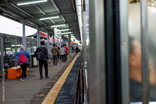 a commuterline train is stopped and passengers are getting out photo