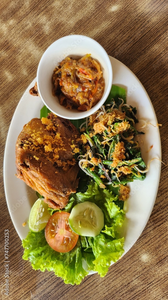 Fried chicken served with a variety of chili sauces and fresh vegetables Fried chicken served with a variety of chili sauces and fresh vegetables